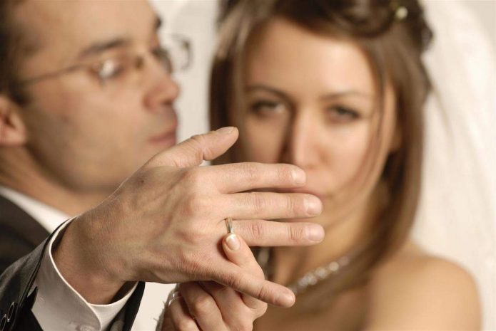 Невеста показывает кольцо на пальце мужа