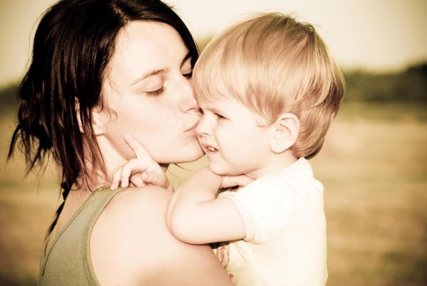 Женщина целует сына