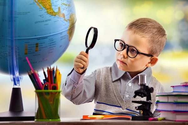 Мальчик в очках изучает глобус