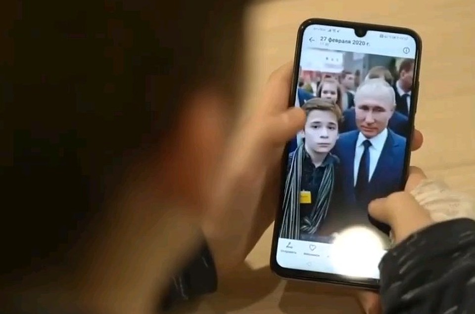 Миша рассматривает фотографии с президентом в своем смартфоне. Фото: Телеканал "Россия"